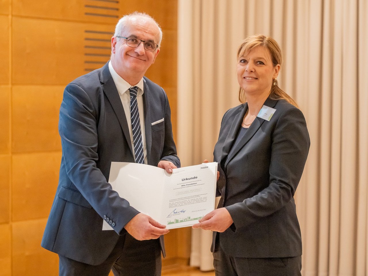 Evi Hoch (Wilo-Foundation) nimmt die Förderurkunde entgegen.