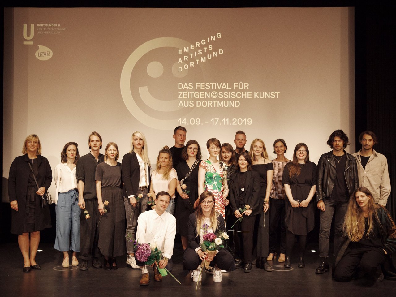 Gruppenfoto des Kuratoren-Team Linda Schröer und Andree Höppe (vorne) mit Künstler und Förderer Wilo-Foundation, Evi Hoch (links), daneben Oriane Durand, Leiterin des Dortmunder Kunstvereins auf der Bühne