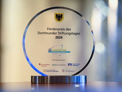 Der Stiftungspreis (rund, Glas mit Aufschrift und Dortmunder Stadtwappen) in Nahaufnahme