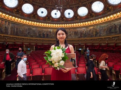 Die Gewinnerin des diesjährigen George Enescu International Competition in der Kategorie Piano Yeon-Min Park (Südkorea) hält einen Blumenstrauß und die Siegerurkunde im Konzertsaal