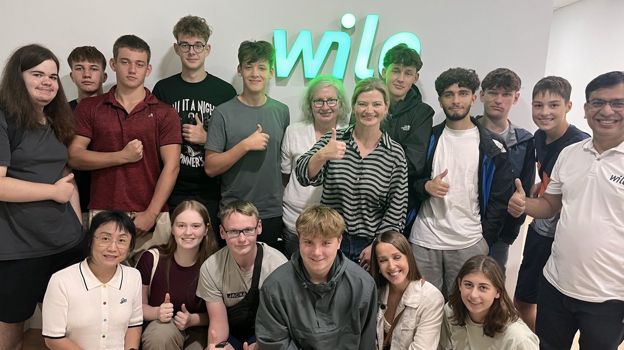 Schülerinnen und Schüler vor dem Wilo-Logo im Wilo Office in Malaysia