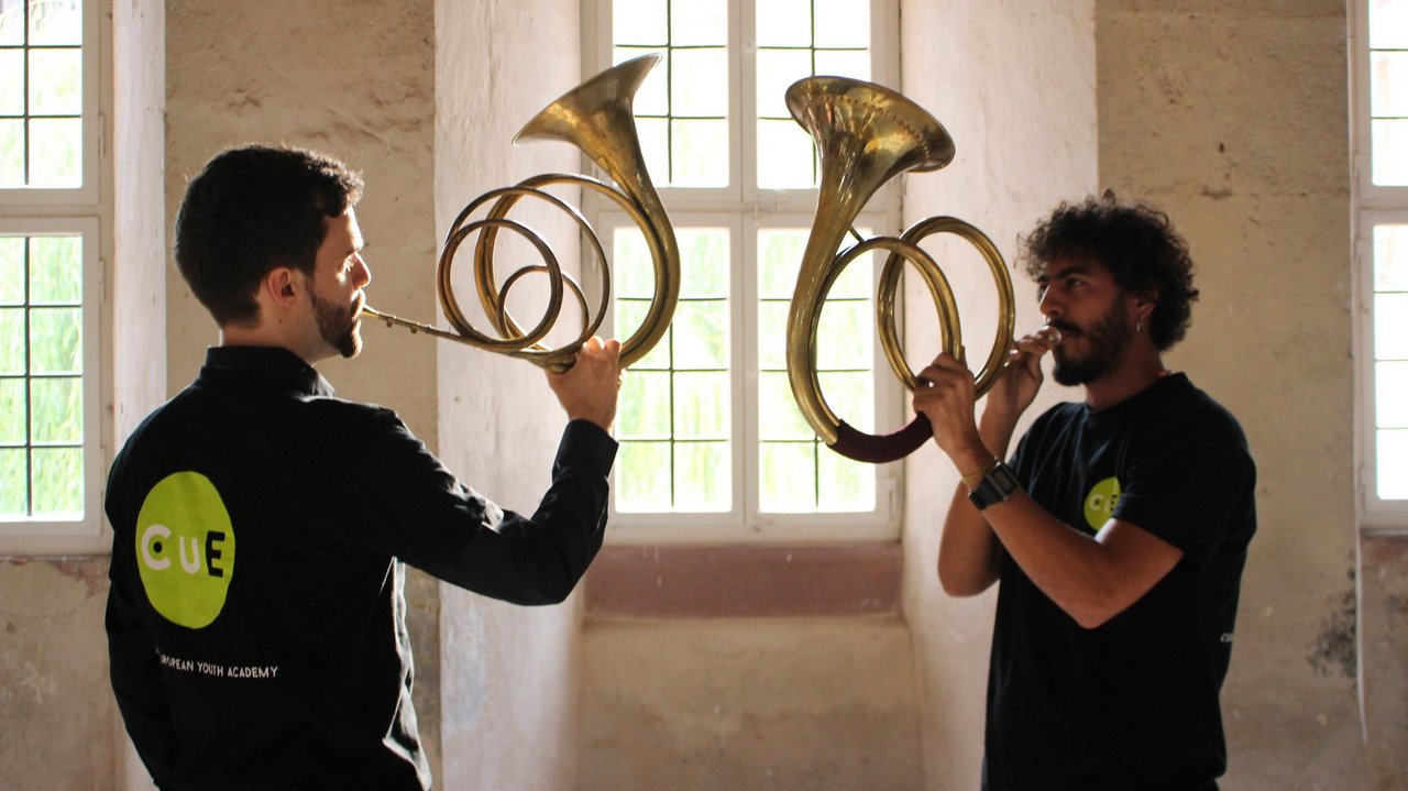 Zwei Männer spielen das Horn, ein Blechblasinstrument