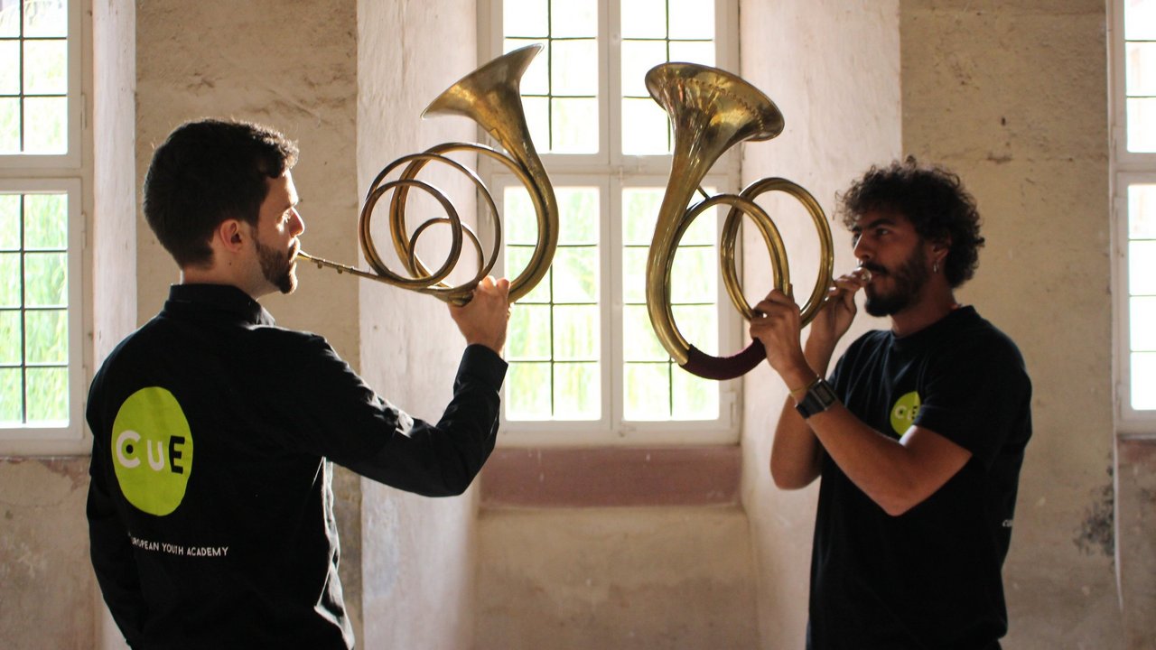 Zwei Männer spielen das Horn, ein Blechblasinstrument