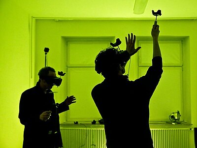 Zwei Menschen mit VR-Brillen in einem neongrün belichteten Raum