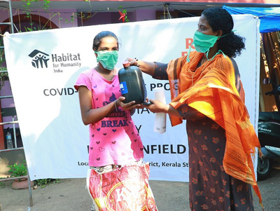 Zwei Frauen mit Atemschutzmasken halten einen Behälter mit Flächendesinfektionsmittel in Pune, Indien