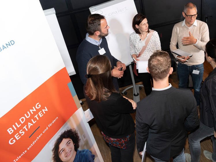 Eine Gruppe Menschen unterhält sich auf dem Netzwerktreffen "Schule in der digitalen Welt"