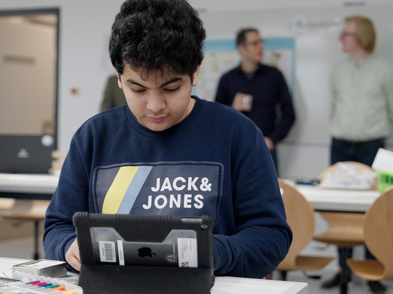 Ein Junge entwickelt sein Projekt in einem Klassenraum mit digitalen und elektronischen Tools